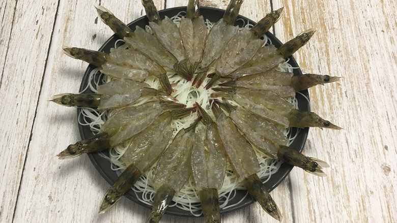 金蒜粉丝蒸虾,泡好的粉丝沥干水分切段铺在盆里，再将虾均匀的铺放在粉丝上