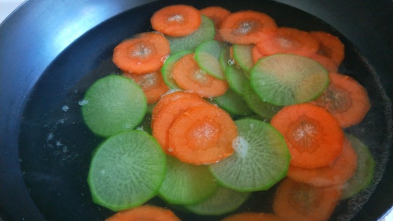 新文美食  青红萝卜蒸肉末,锅中放水烧开，倒入青红萝卜。