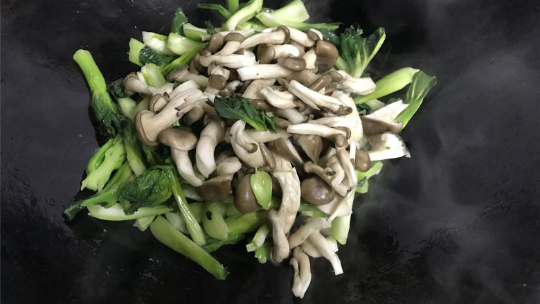  秀珍菇炒青菜,翻炒均匀后加入切碎的秀珍菇。
