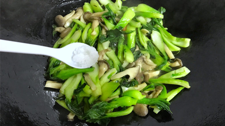  秀珍菇炒青菜,炒匀后加入适量盐。