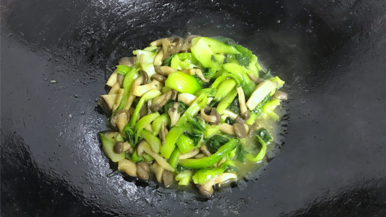 秀珍菇炒青菜,炒匀后，加入少许的水煮开。
