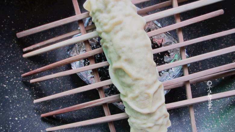 熏豆腐皮卷,支上架子上面放上刚才蒸好的豆皮卷。