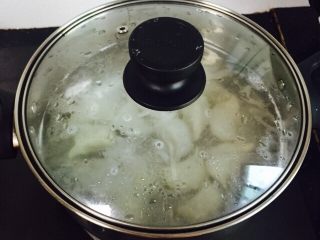 酸汤水饺,盖上锅盖大火烧开后待饺子逐个浮上水面并搅拌一下防止粘锅底