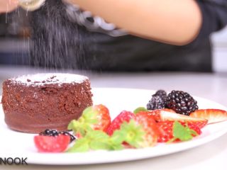浓醇黑巧克力流心蛋糕,撒上糖粉，放上装饰的水果
