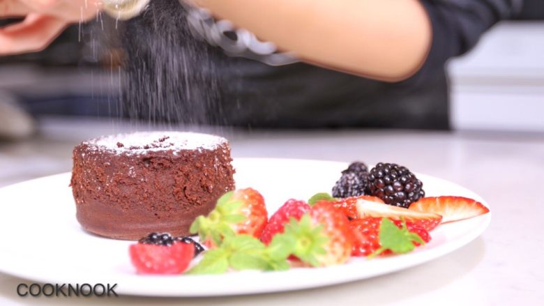 浓醇黑巧克力流心蛋糕,撒上糖粉，放上装饰的水果