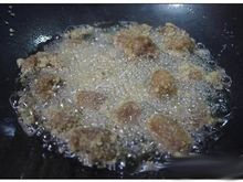 酸甜咕咾肉,油锅温度升到約160℃（丟入多余的小粉团開始冒小泡）时放入肉块，炸至八分熟后捞出。