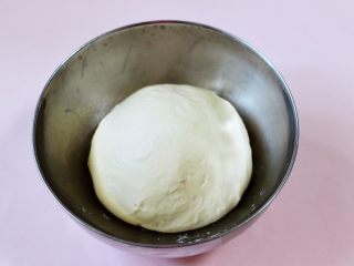 奶香四溢的紫薯小餐包,把面团滚圆放入容器内，盖上保鲜膜，进行第一次发酵。