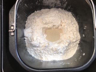 椰蓉小餐包,先把牛奶倒入面包机里，对角分别放入白糖和盐，加入玉米油和奶粉，倒入高筋面粉，在上面挖个洞，倒入酵母粉，然后用面粉盖住酵母粉，启动面包机自动和面20分钟。