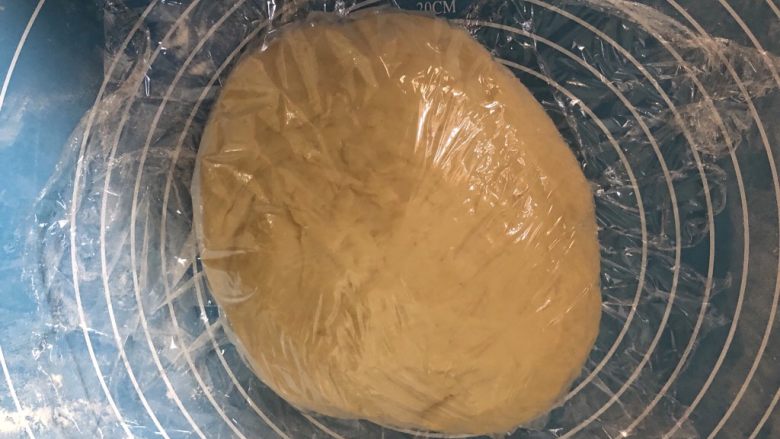 椰蓉小餐包,发酵完成后取出盖上保鲜膜醒十分钟。(检查是否发酵好，可以手指沾面粉在面团上戳个洞，洞口不回缩不塌陷就是好了。)