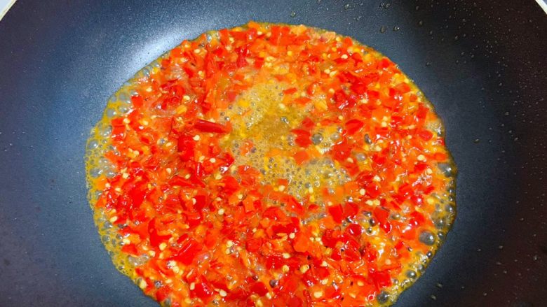 剁椒蒸鸡翅,锅中水倒掉后擦干，加入适量油烧热，加入5勺剁辣椒炒开