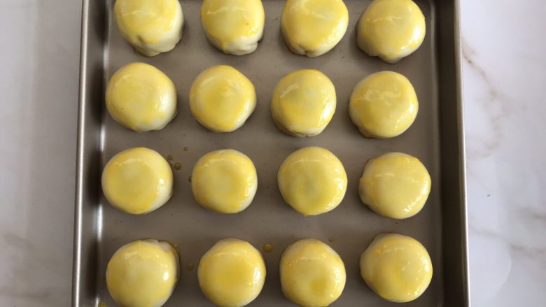 蛋黄酥（黄油版）,全部包好后放入烤盘中，刷上一层鸡蛋液