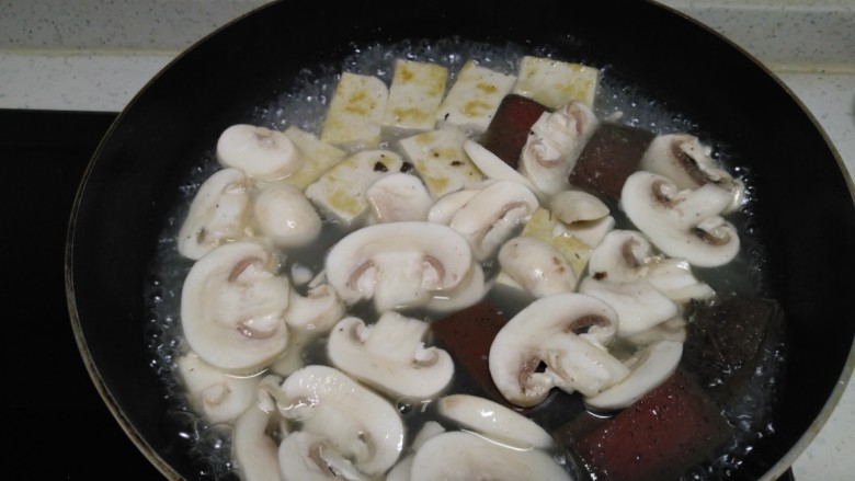 豆腐炖猪血蘑菇,放入蘑菇片。