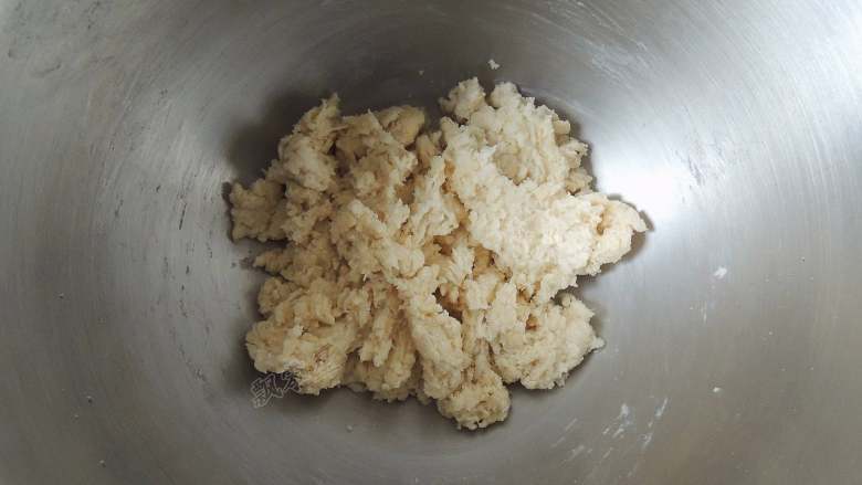 芝麻葱花面包,先用筷子手动将所有材料搅拌成没有干面粉的絮状面团。主要是为了避免启动机器以后，面粉飞溅出来。