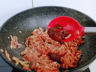 老北京肉丝炸酱面,起油锅，加入腌制好的肉丝翻炒，再加入豆瓣酱，翻炒均匀。