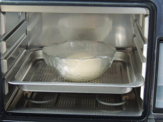 芝麻葱花面包,盖上保鲜膜或者湿布，放入蒸烤箱中，关紧烤箱门。