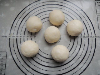 芝麻葱花面包,将面团平均分割成6等份，滚圆之后，盖上保鲜膜，松弛20分钟左右。