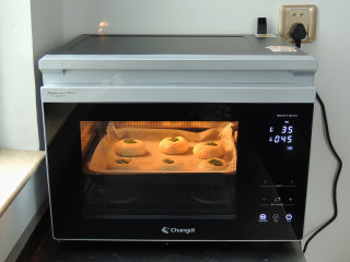 芝麻葱花面包,将烤盘放入蒸烤箱中。选择“发酵”模式，设置温度35度，时间45分钟。