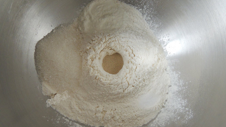 砂糖麻花面包,将所有的干性材料全部放入厨师机的搅拌桶中，酵母粉放在中间，不要和糖、盐接触。