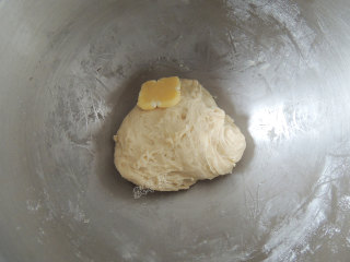 砂糖麻花面包,启动厨师机，将面团揉至光滑以后，加入软化的黄油。