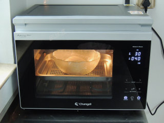 砂糖麻花面包,将面团重新滚圆，放入碗中，盖上保鲜膜，放入蒸烤箱中，选择“发酵”模式，设置温度30度，时间40分钟。