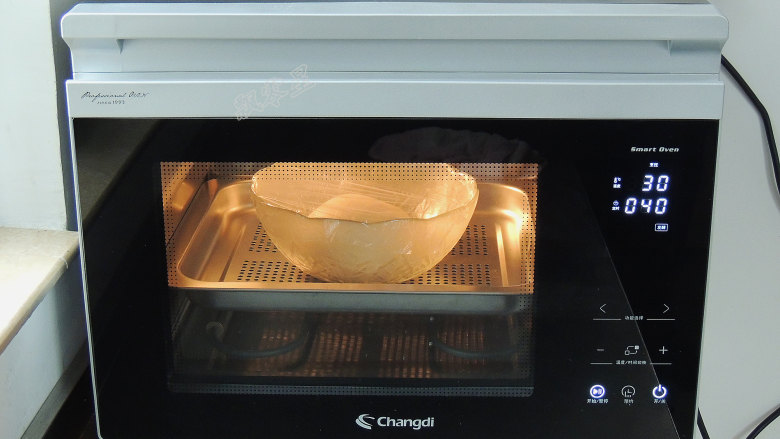 砂糖麻花面包,将面团重新滚圆，放入碗中，盖上保鲜膜，放入蒸烤箱中，选择“发酵”模式，设置温度30度，时间40分钟。