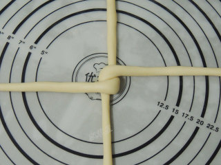 砂糖麻花面包,横向的那股长条两端左右折叠，交错压住上面那股长条。