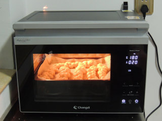 砂糖麻花面包,烤箱预热完成以后，将烤盘放入烤箱，选择“上下烤”模式，温度180度，时间20分钟。