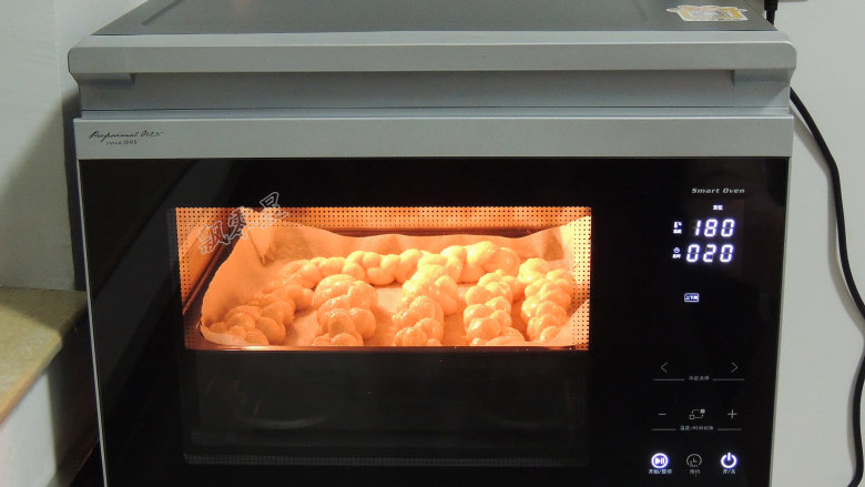 砂糖麻花面包,烤箱预热完成以后，将烤盘放入烤箱，选择“上下烤”模式，温度180度，时间20分钟。