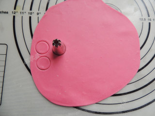 卡通小猪馒头,粉色面团擀开成厚薄均匀的面片，用中号裱花嘴顶端按压出圆形面片，用来当做猪鼻子。