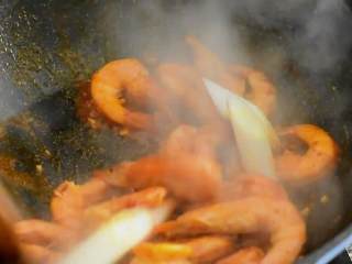 油焖大虾好吃也好做，红红火火的颜色也吉祥,倒入虾，继续翻炒，加入料酒、蚝油、葱段，再次炒匀。