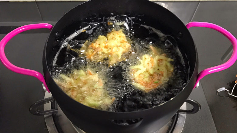 萝卜丝饼,锅中倒入适量油，油温6成热时用勺子舀起一勺萝卜丝，放入锅中。
