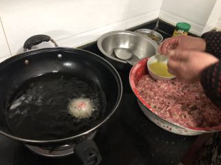 炸肉圆,用手抓一团肉糜(根据需要控制一个肉圆的大小)，把它整成圆形放入油锅中，开始不要动它，等感觉底部变色以后用锅铲将它翻面。
