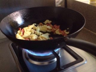 鸡蛋炒米饭,3.把火腿和鸡蛋放入锅中炒，炒2-3分钟。