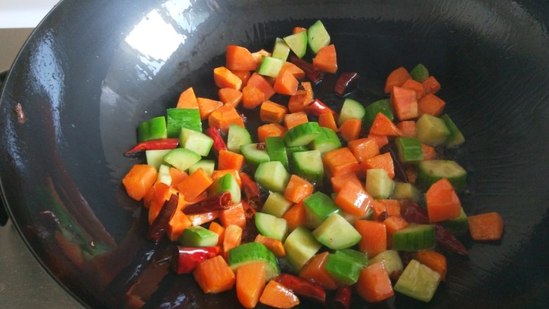 新文美食  麻辣鸡丁,倒入胡萝卜黄瓜丁翻炒均匀。