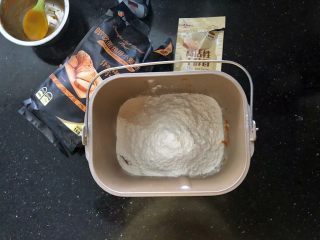 南瓜豆沙排包,2、把主面团里除了黄油之外的所有材料放入面包桶里，先液体后粉类，干酵母最后再放。