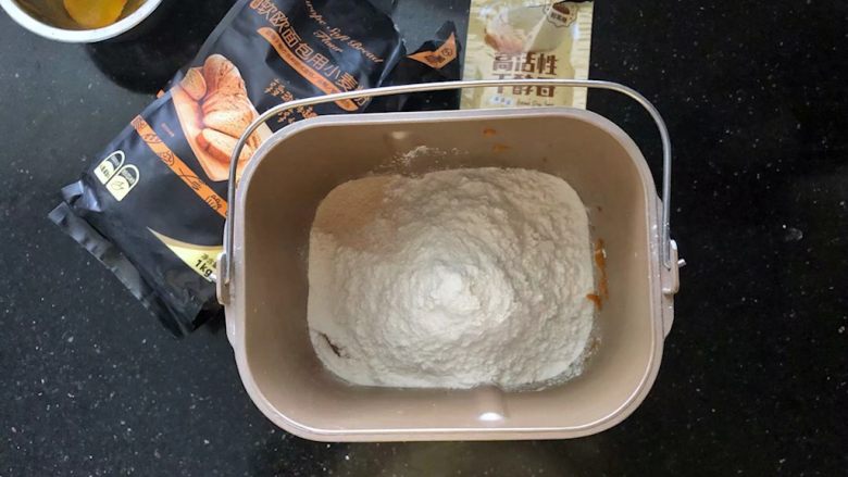 南瓜豆沙排包,2、把主面团里除了黄油之外的所有材料放入面包桶里，先液体后粉类，干酵母最后再放。
