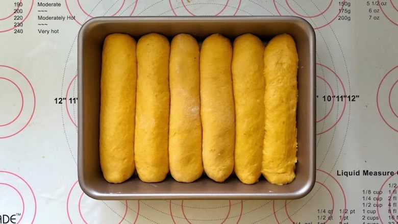 南瓜豆沙排包,14、收口向下码入学厨9寸烤盘中，盖上保鲜膜进行二次发酵。
