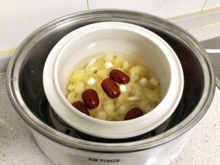 百合红枣糯耳莲子汤,加入5倍的清水，放入电炖锅，盖好盖子，选择“甜品汤”模式，开始煲制；如果没有电炖锅，可以放入普通炖盅，大火烧开，转小火慢炖两个小时。