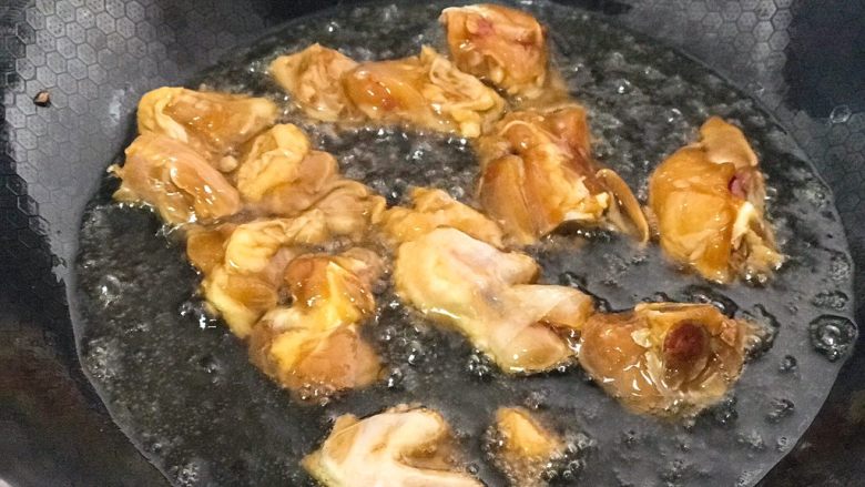 辣子鸡,锅内入油烧热，将腌制好的鸡块放入油锅中炸，直到鸡块表面颜色金黄时捞出放凉片刻