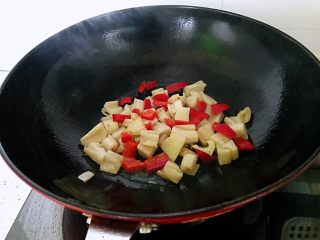 糖醋藕丁,锅中放少许油，下藕丁翻炒，下柿子椒，翻炒1分钟。