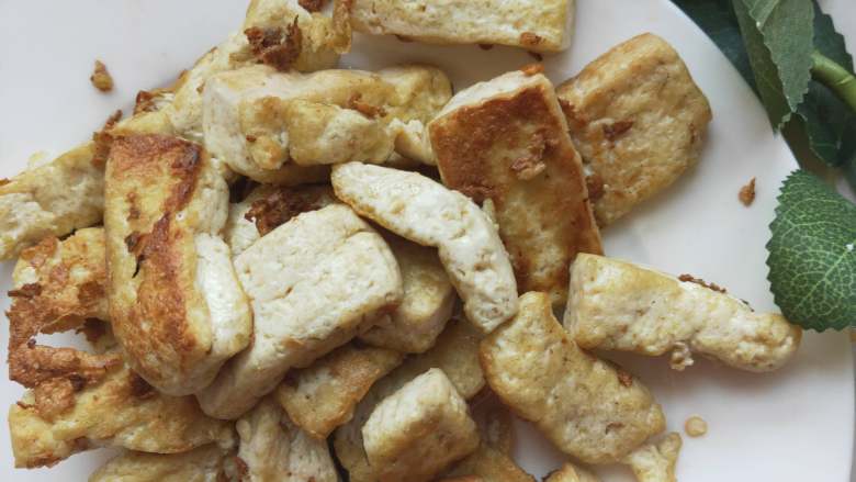 豆腐炒彩椒,锅内倒入适量油，放入切好的豆腐，炸至两面金黄捞出装盘备用