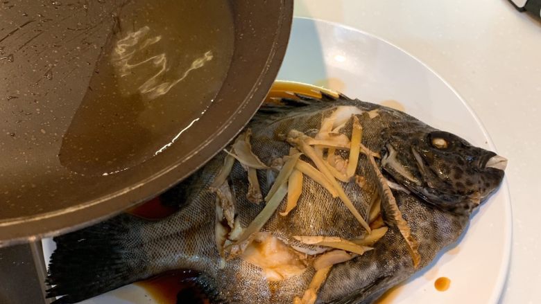 清蒸斑石鲷,把烧好的油淋到鱼身上，出锅