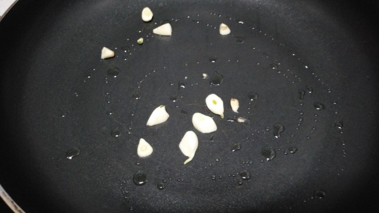 西葫芦炒蘑菇,不粘锅中放入少许油，炒香蒜瓣。