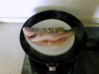 清蒸鲈鱼#年年有余#,放入开水锅加盖蒸8分钟关火。（蒸鱼时间不能过长，会导致蛋白质老化影响口感）
