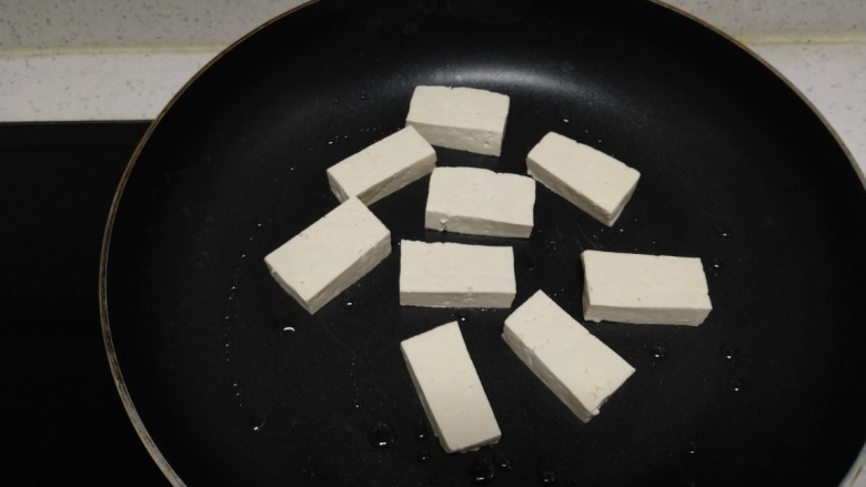 豆腐炒黄豆芽,不粘锅中放入少许油，放入豆腐。