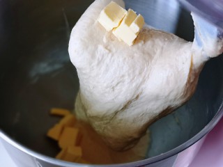 超级松软零失败的全麦蜜豆小餐包,10分钟后加入室温软化的黄油，再次启动厨师机2档，揉20分钟，揉到不容易破的手套膜，就可以进行发酵了。