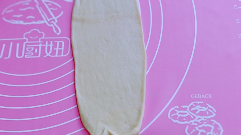 葱香四溢的全麦酸奶面包卷,取一块面团，用擀面杖擀成长舌状。