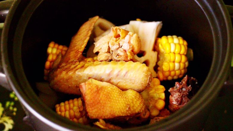 土鸡炖玉米甜藕汤,先把玉米和藕块放入沙锅底下，把鸡块放到上面。