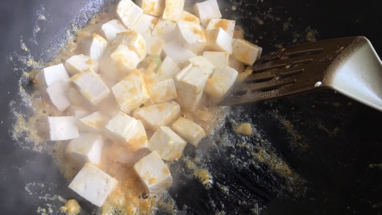 蟹黄豆腐,倒入豆腐块，轻轻拌一下，干的话加一点水，放盐出锅