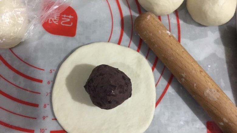 日式红豆包,将面团擀成圆形面片，将红豆馅放中心